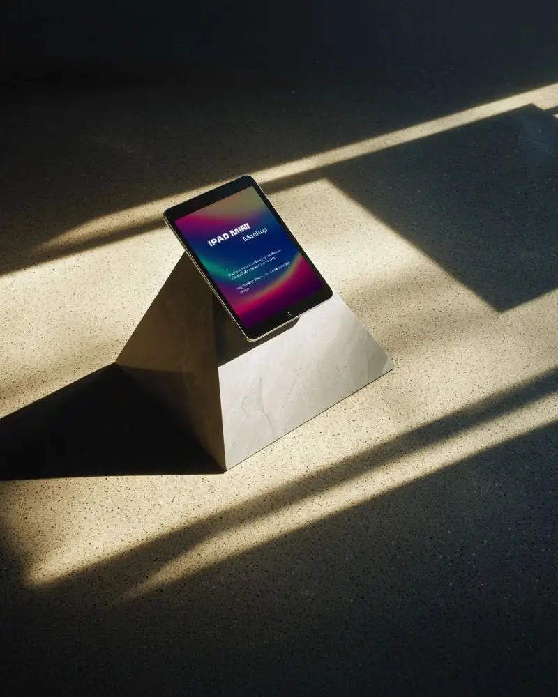 minimalist-ipad-mini-mockup-on-stone-pyramid-stand-in-sunlit-modern-interior-with-soft-lighting