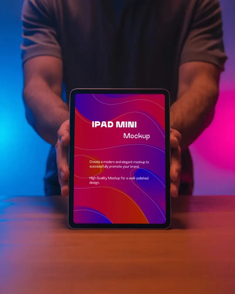 Ipad Mini Mockup Hand Held Upright On Wooden Table With Blue And Pink Neon Lighting