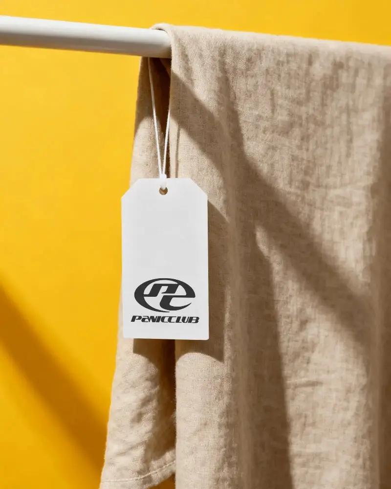 Cloth Label Hanging On Pole With The String Against Solid Color Background For Branding