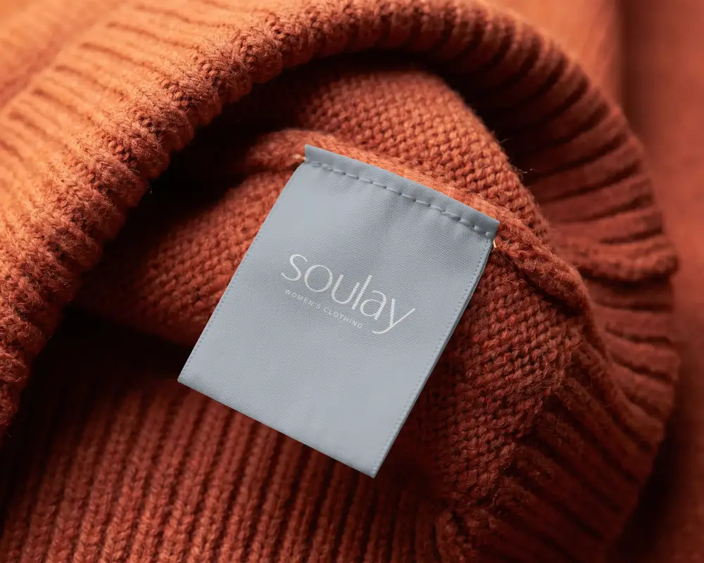 High Resolution Clothing Label Mockup On Knitwear With Stitched Clear Fabric Tag