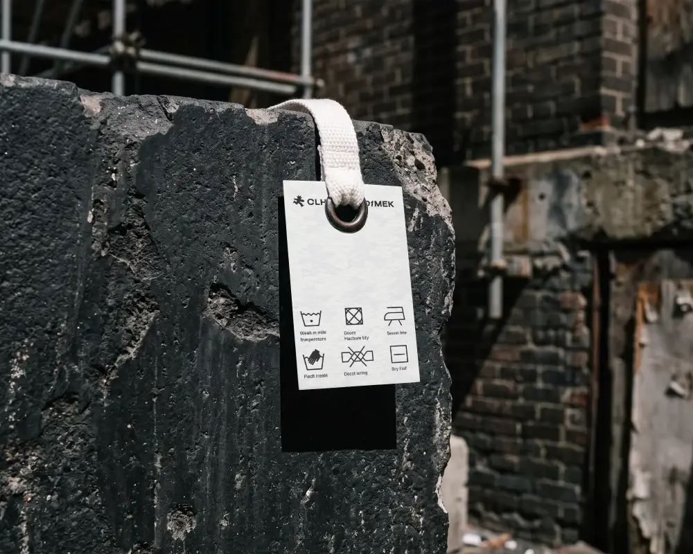 Blank Texture Pendant Label Mockup Hanging On Rough Stone Surface For Design Showcase