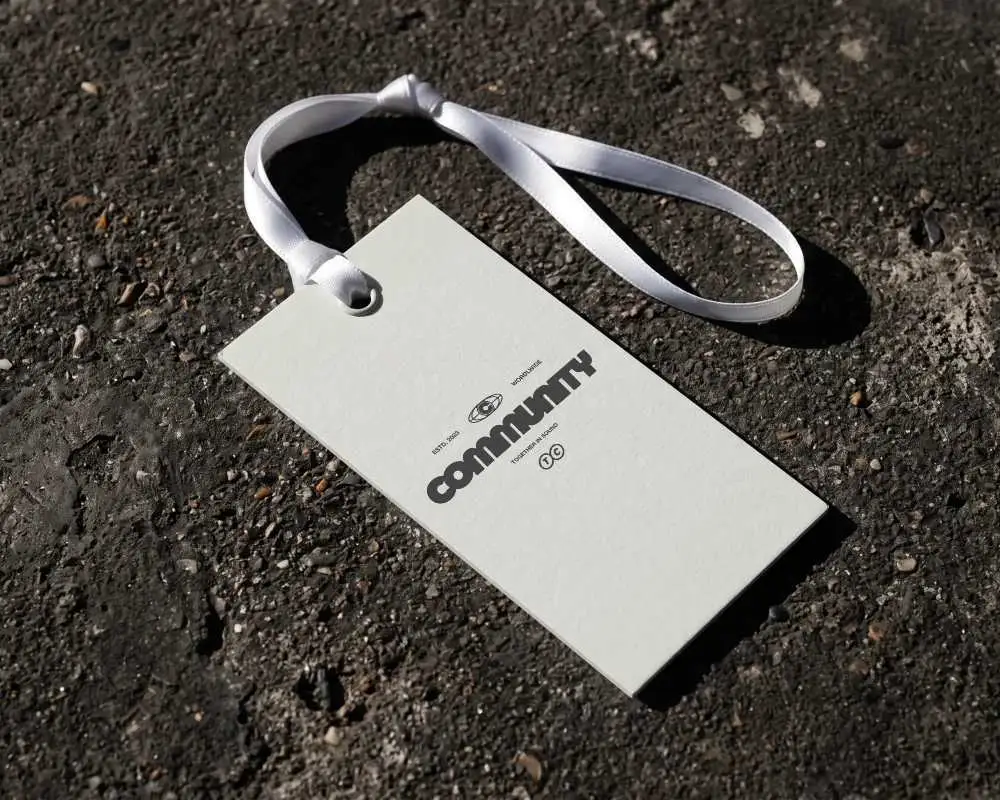 Blank Hanging Label Mockup On Rough Textured Surface With Elegant Ribbon Attachment