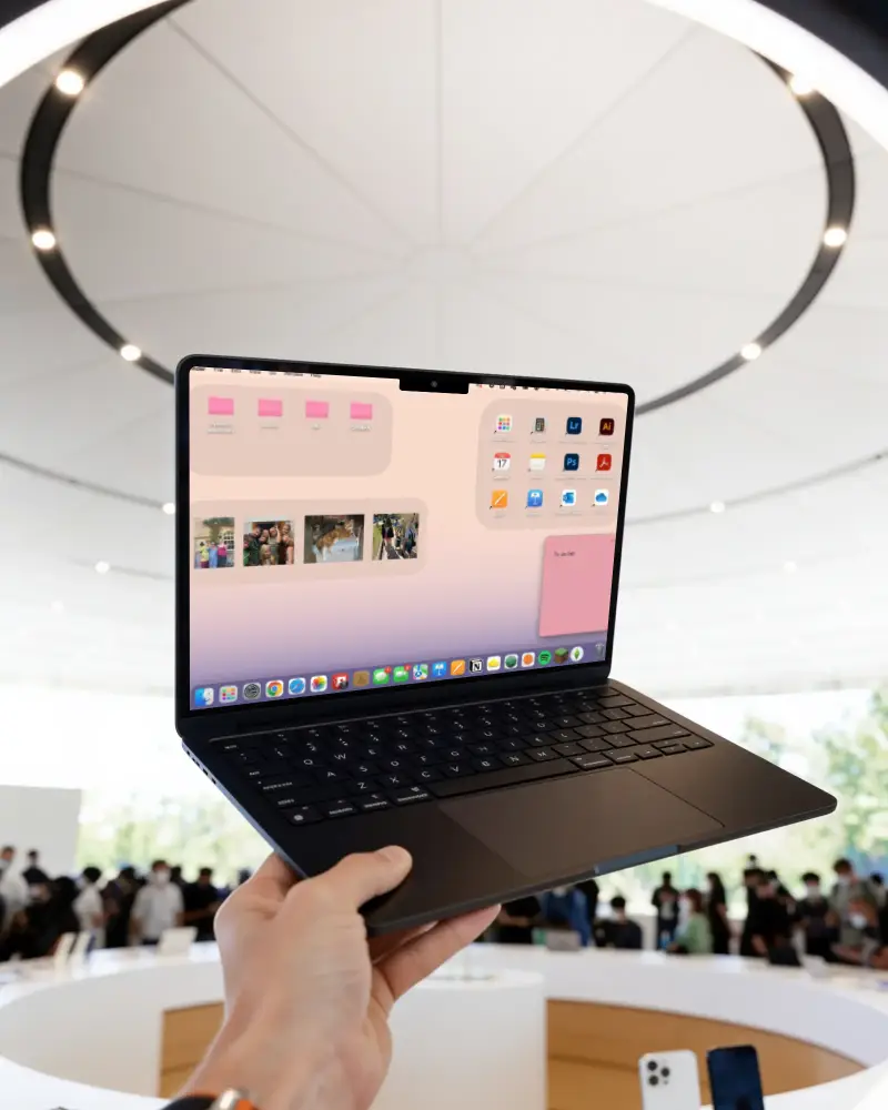 Hand Holding Modern Macbook Pro M2 Mockup With Blank Screen In Busy Tech Store Setting