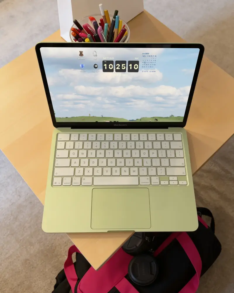 Modern Macbook Neo Placed On Corner Of Table Next To Stationery And Gear Bag Accessories