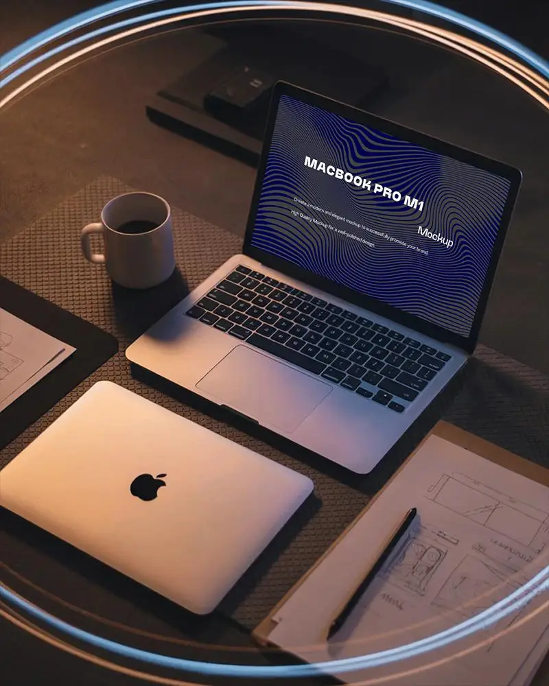 Macbook M1 Pro Mockup On Wooden Desk With Coffee Mug Paper Sketches And Closed Macbook In Soft Warm Ring Light