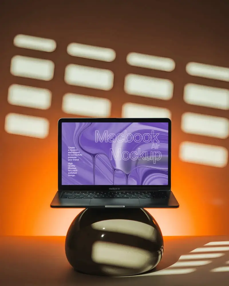 Sunset Lit Studio Macbook Air M1 Mockup On Glossy Orb Stand With Dramatic Grid Shadows