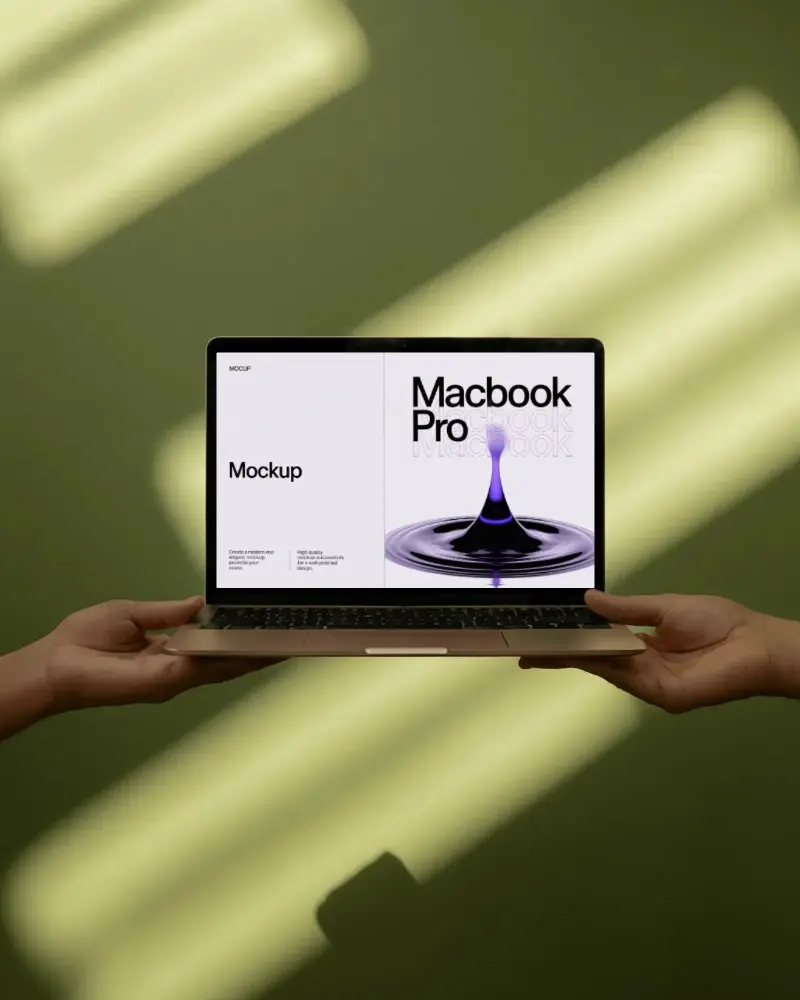 Macbook M1 Pro Mockup Held By Two Hands Against Green Wall With Soft Sunlight Stripes