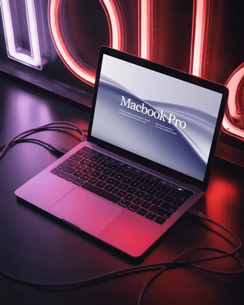 Wired Macbook M1 Pro Mockup Against Neon Sign With Pink Purple Light Reflections