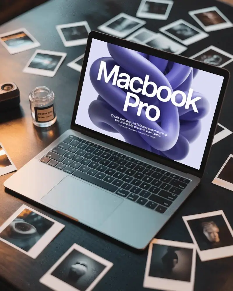 Macbook Pro M1 Mockup On Dark Desk Surrounded By Polaroids Camera And Film Developer Jar