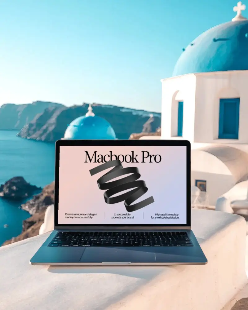 macbook-pro-m1-mockup-on-white-terrace-overlooking-blue-domes-and-aegean-sea-in-santorini