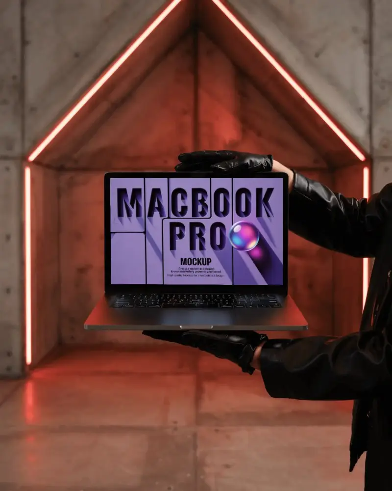 macbook-m1-pro-mockup-held-by-gloved-hands-in-front-of-concrete-wall-with-red-led-lines
