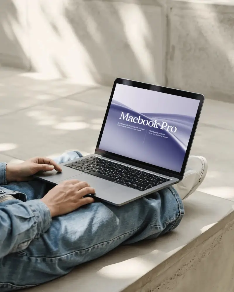 macbook-m1-pro-mockup-on-lap-in-sunlit-concrete-space-with-denim-outfit-and-soft-shadows