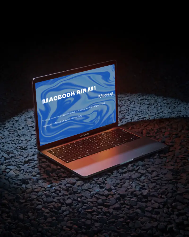 Macbook Air M1 Mockup On Dark Gravel Surface With Vivid Spotlight And Warm Glow Nighttime And Edgy Showcase Style
