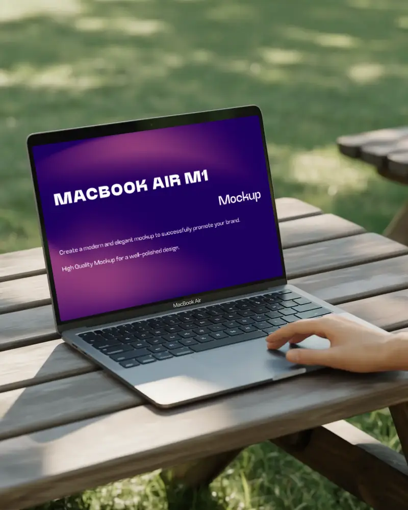 Macbook Air M1 On Wooden Picnic Table Outdoors With Hand Interacting Green Grass Background Natural Lighting