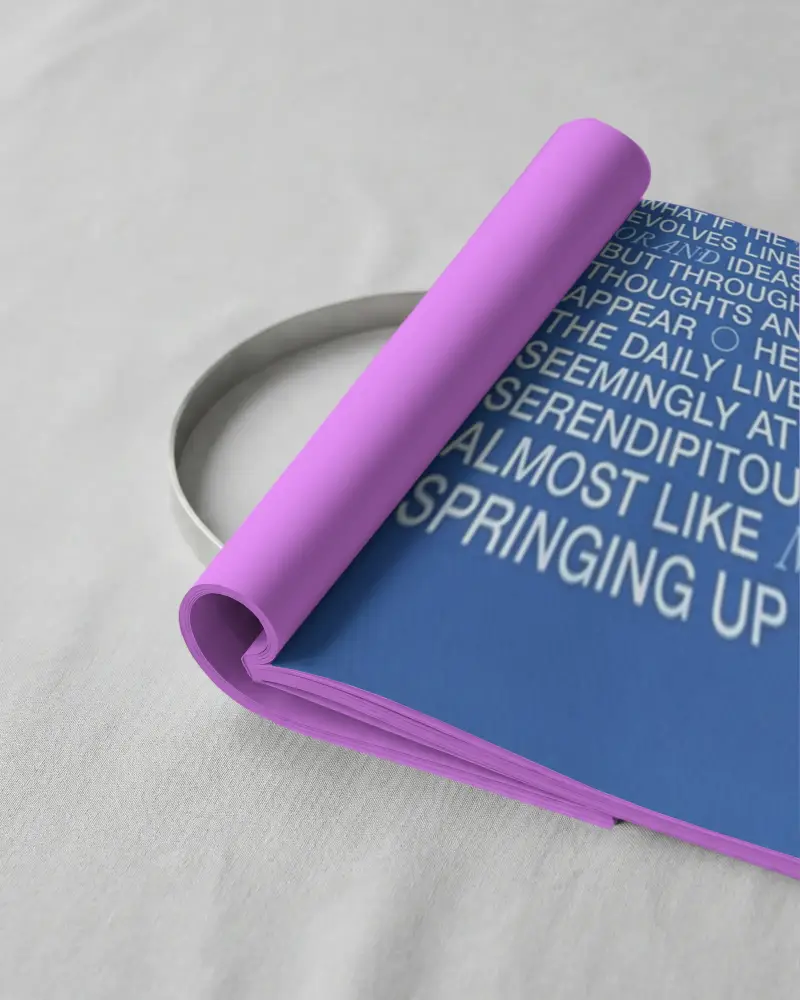 Blank Magazine Mockup Featuring A Partially Rolled Page On A Textured Fabric Surface