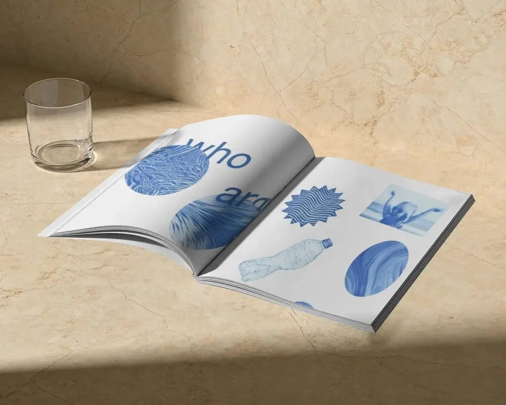 Open Magazine Mockup Showcasing Flat Layout On Textured Marble Surface With Glass