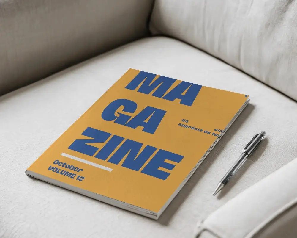 Angled Softcover Magazine Mockup On Light Fabric Sofa With Pen 0169