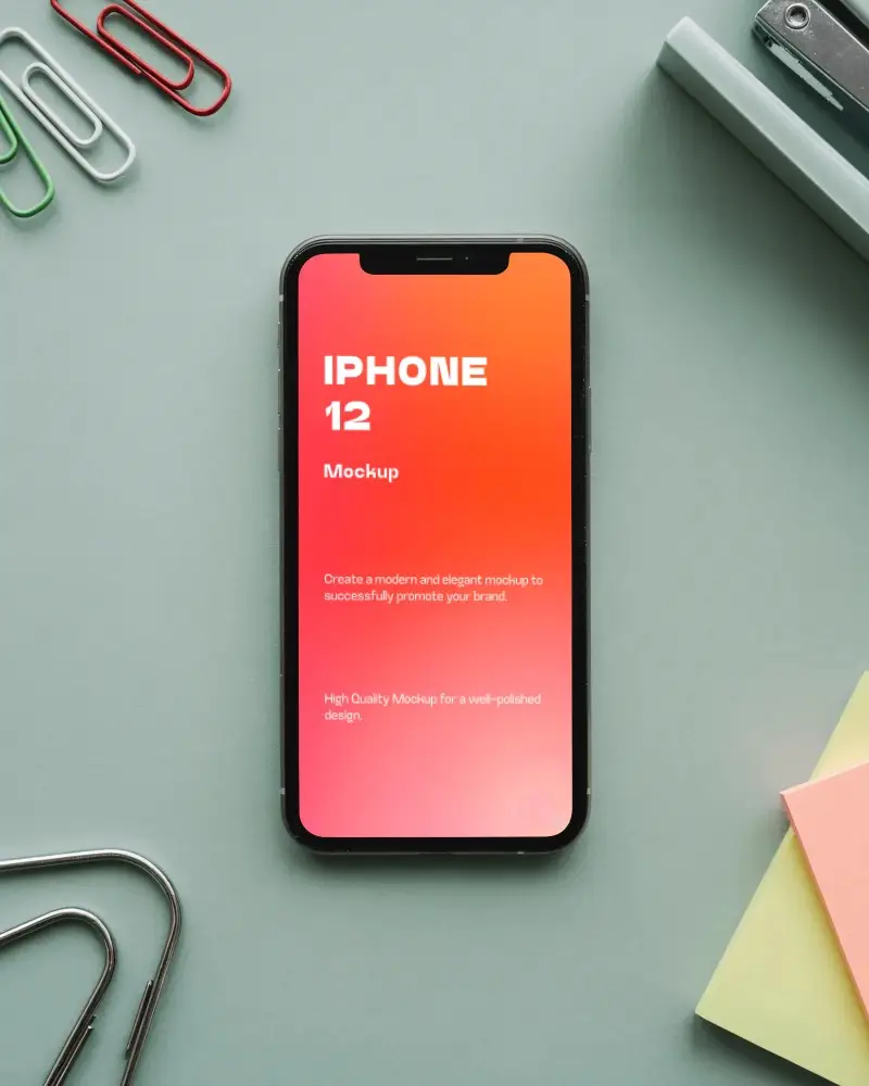 Top View Iphone 12 Mockup On Pastel Desk With Stationery Items And Paper Clips