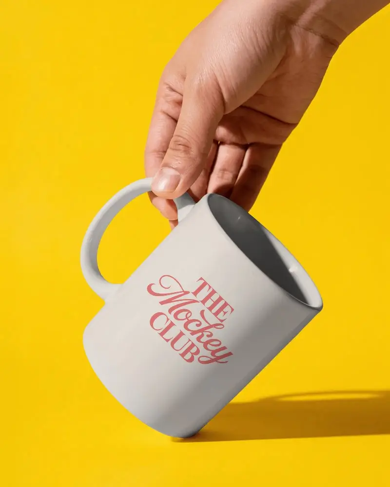 Hand Holding Minimalist Ceramic Mug Against Vibrant Solid Background Perfect For Custom Designs