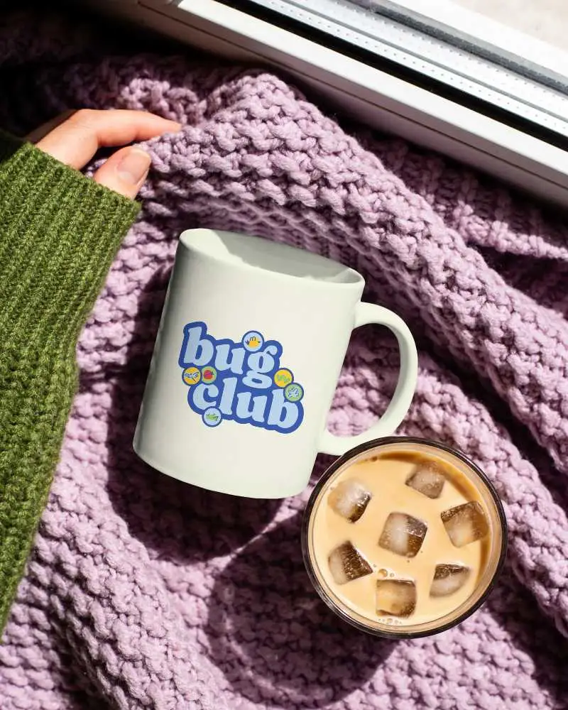 Top View Minimalist Mug Mockup With Iced Coffee Placed On Textured Cozy Fabric Background