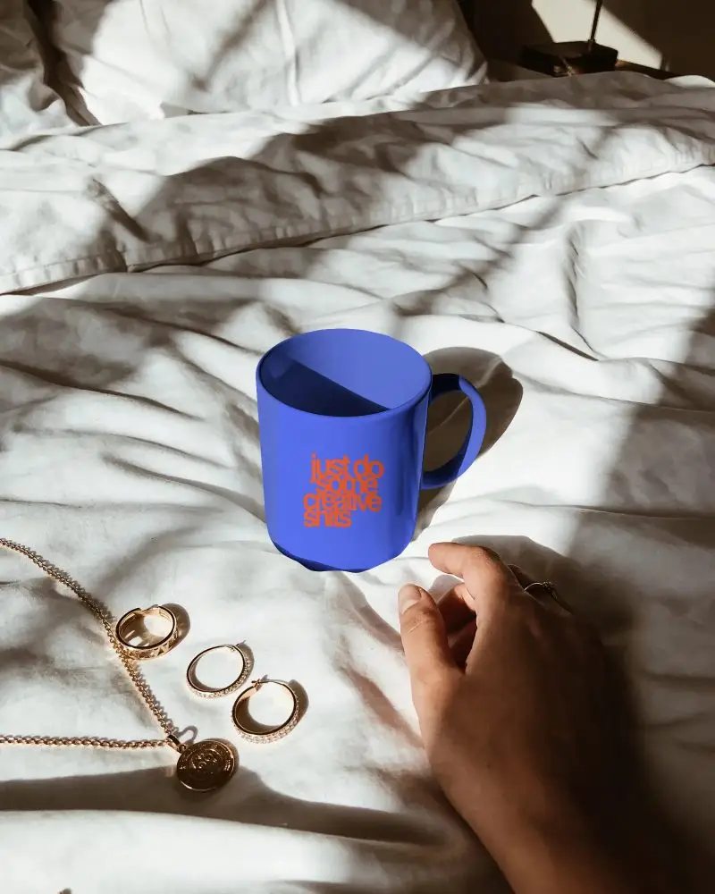 Trendy Home Mug Mockup Next To Gold Jewelry Pieces On Wrinkled Luxury Bed Texture