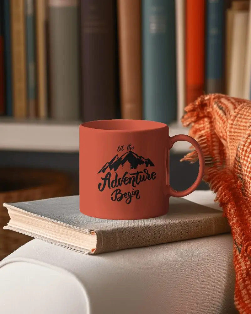 Cozy Study Mug Mockup White Ceramic Mug On Open Book With Warm Orange Scarf And Bookshelf Background Relaxed Learning Atmosphere Modern Library Mug Mockup Elegant White Mu