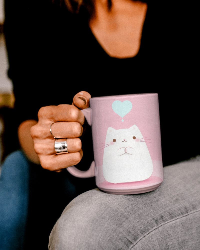Relaxed White Mug Mockup Held By Hand With Rings And Jeans Background