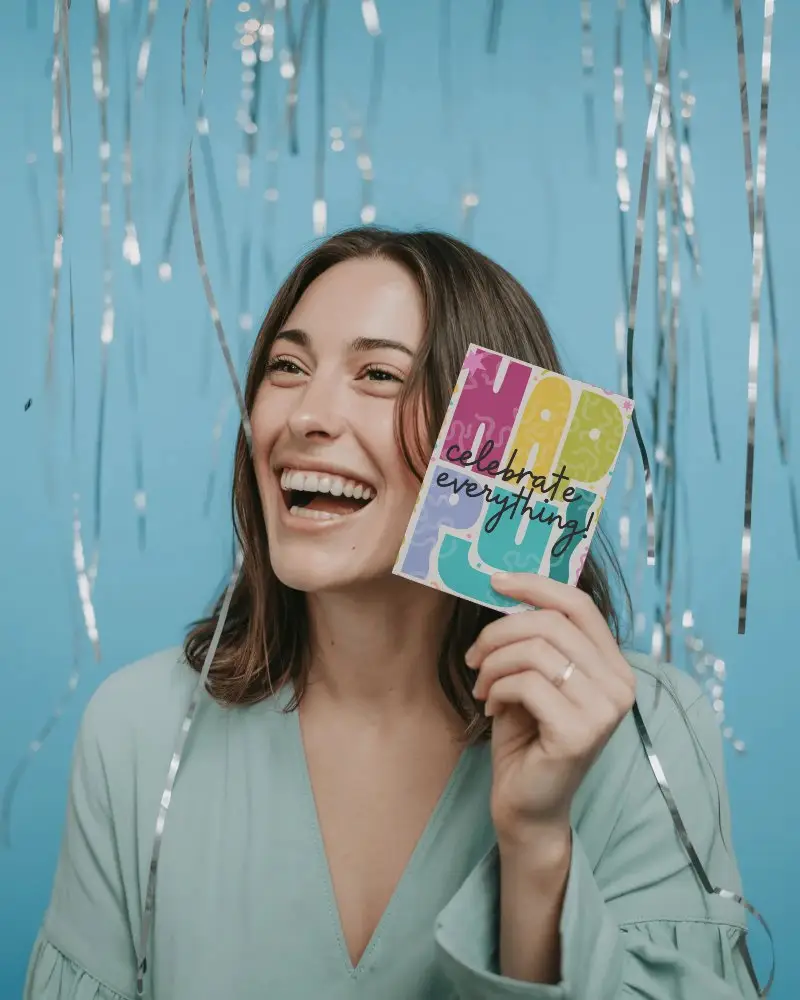 Happy Woman Holding New Year Greeting Card Mockup Celebration Hanging Decorations Background