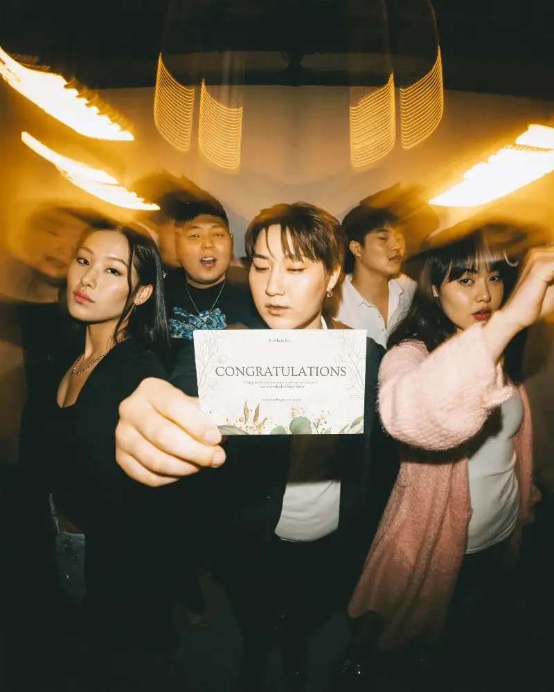 Group Of Friends Showing Empty Card Mockup For New Year Wishes And Party Invitation Ideas