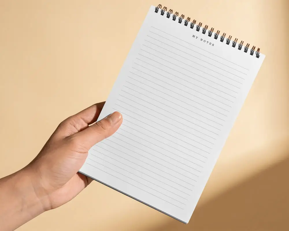 Hand Holding Spiral Bound Notebook Mockup For Customized Stationery Designs