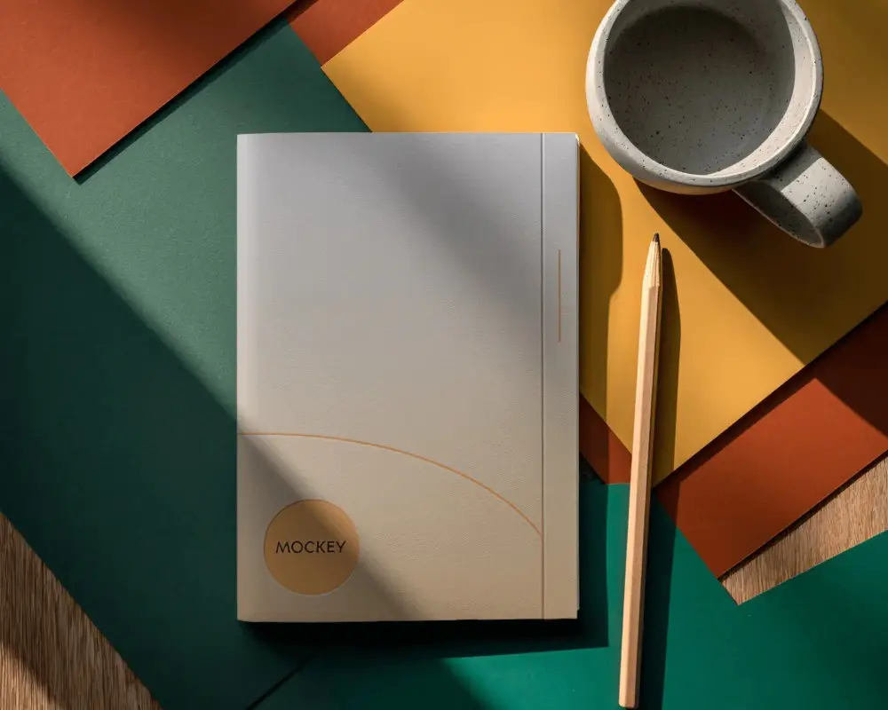 Top View Closed Notebook Mockup With Working Accessories On Tabletop