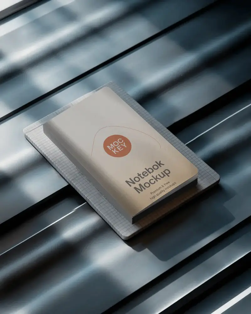 premium-notebook-mockup-on-metal-surface-with-grid-paper-underlay-in-soft-natural-light