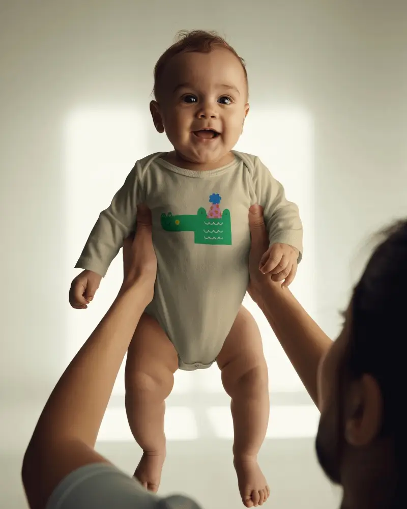 Lifestyle Baby Onesie Mockup With Parent Holding Baby In Soft Window Light
