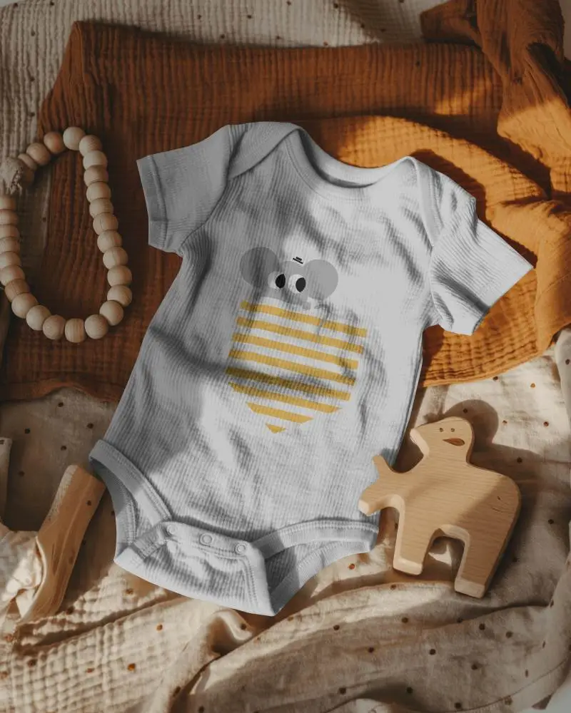 Boho Flatlay Baby Onesie Mockup On Textured Fabric With Wooden Toy Accen