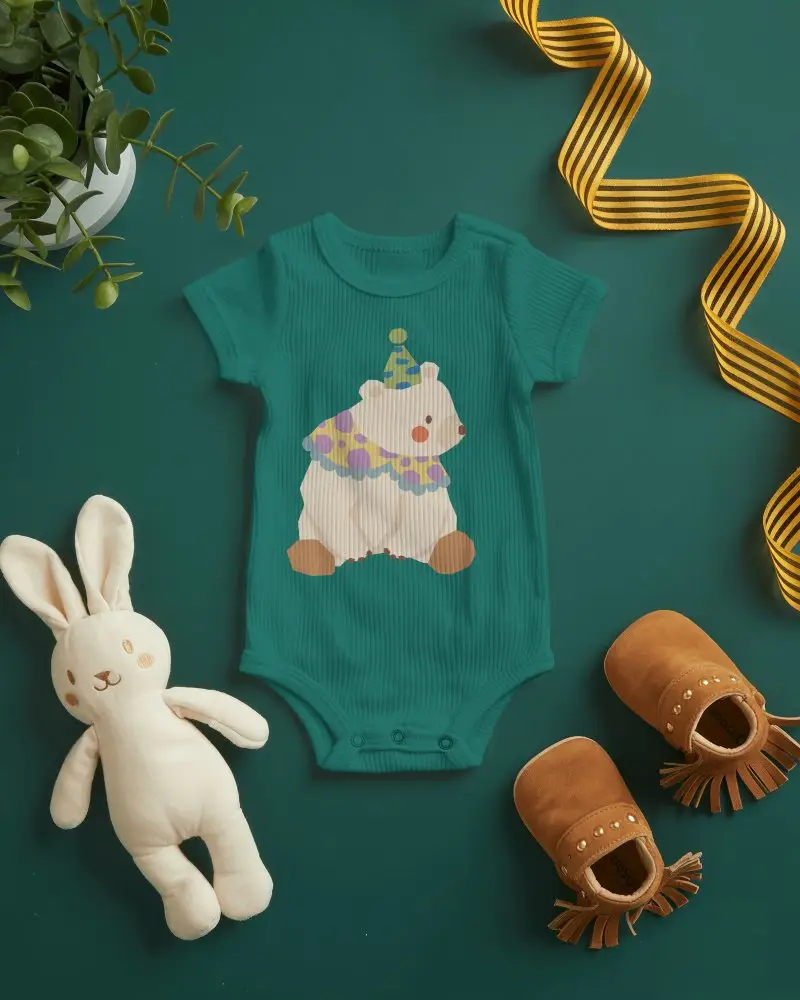 Modern Baby Onesie Mockup On Deep Green Background With Styled Nursery Props