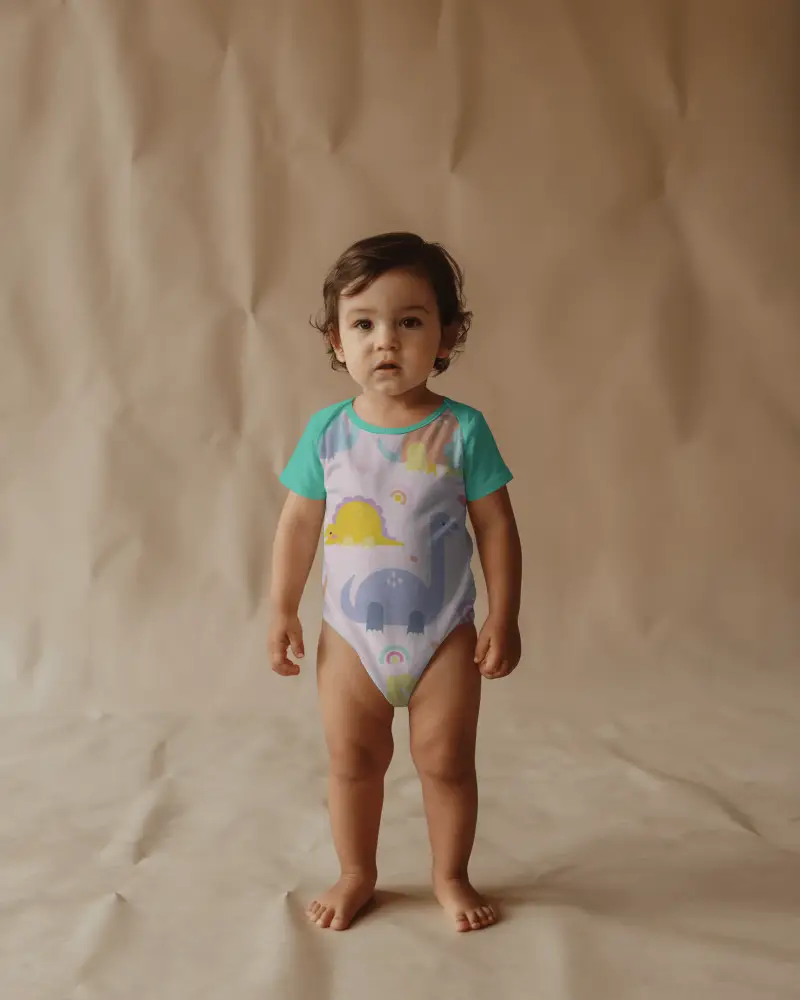 Full Body Baby Onesie Mockup Front View Standing On Textured Backdrop With Studio Depth