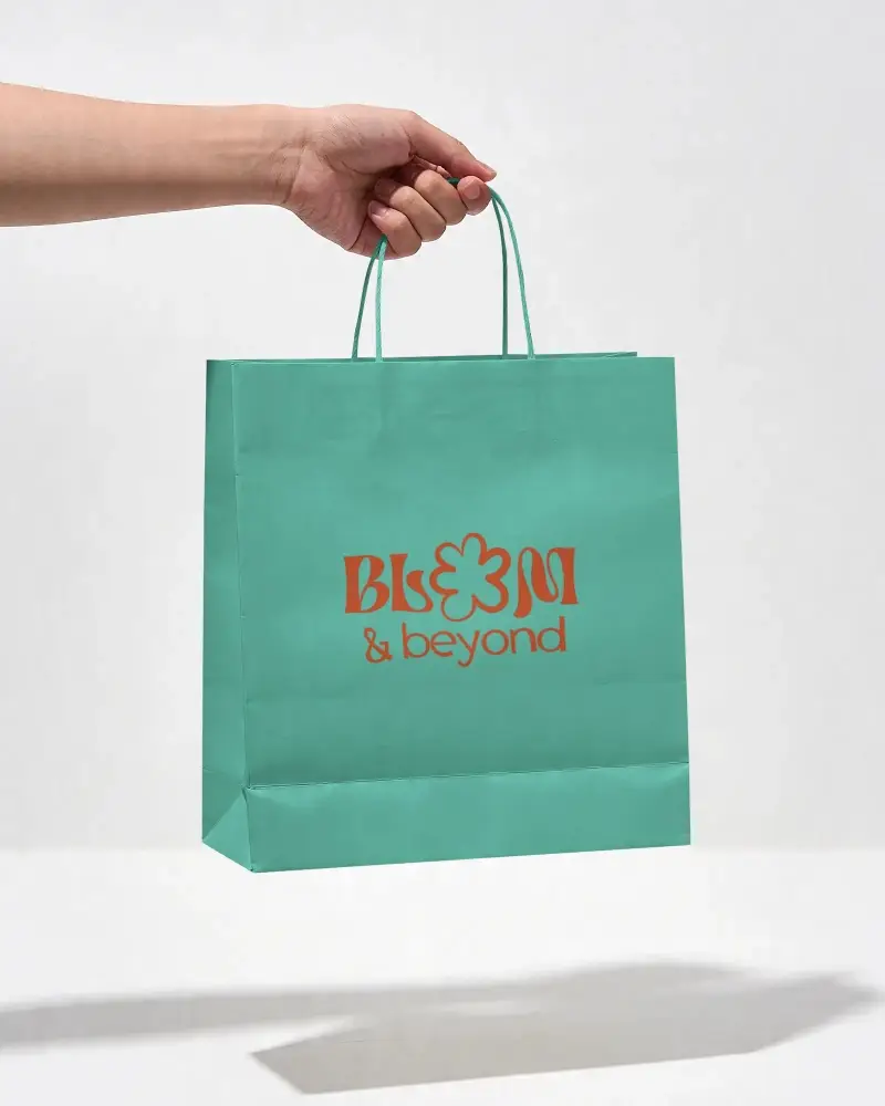 Eco Friendly Paper Bag Mockup Held By Hand With Folded Bottom And Soft Shadow
