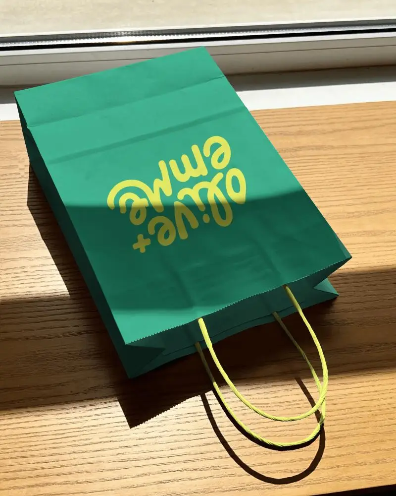 Paper Shopping Bag Mockup With Clear Twisted Handles On Natural Wooden Tabletop Surface