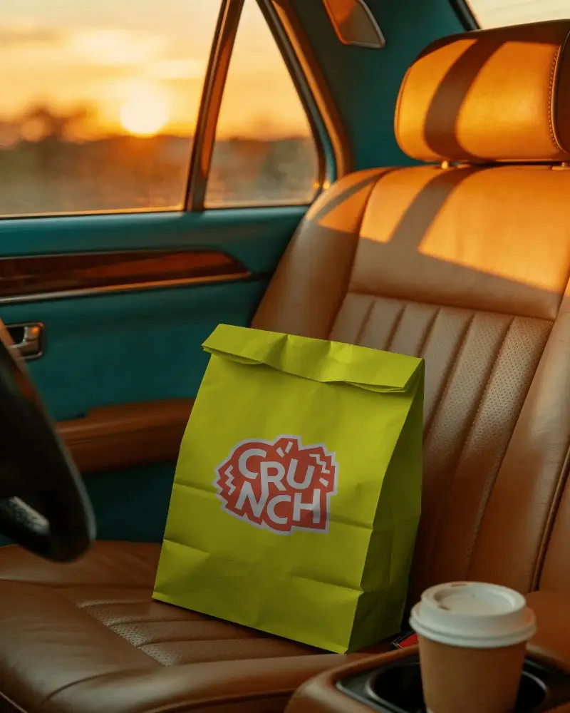 Fold Top Paper Bag Mockup On Vehicle Leather Seat Near Travel Coffee Cup In Car