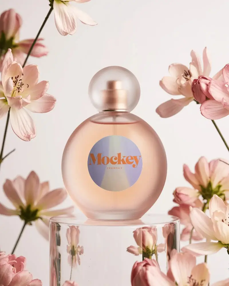 Elegant Round Perfume Bottle Mockup Surrounded By Delicate Floral Arrangement Setup