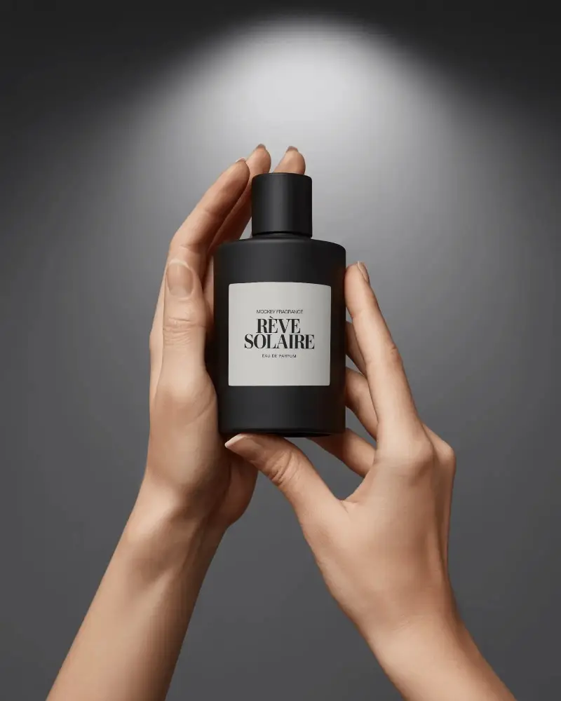 Luxury Perfume Mockup Matte Black Bottle Held In Hands With Soft Spotlight Background