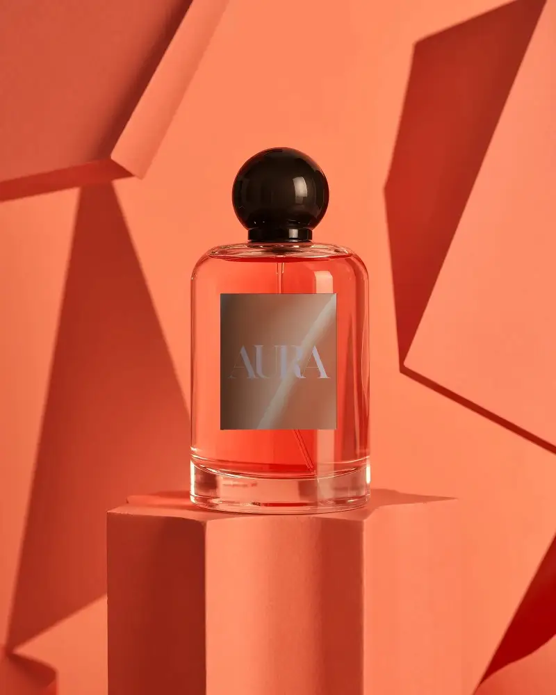 Luxury Perfume Mockup Coral Glass Bottle On Geometric Pedestal With Warm Abstract Shapes