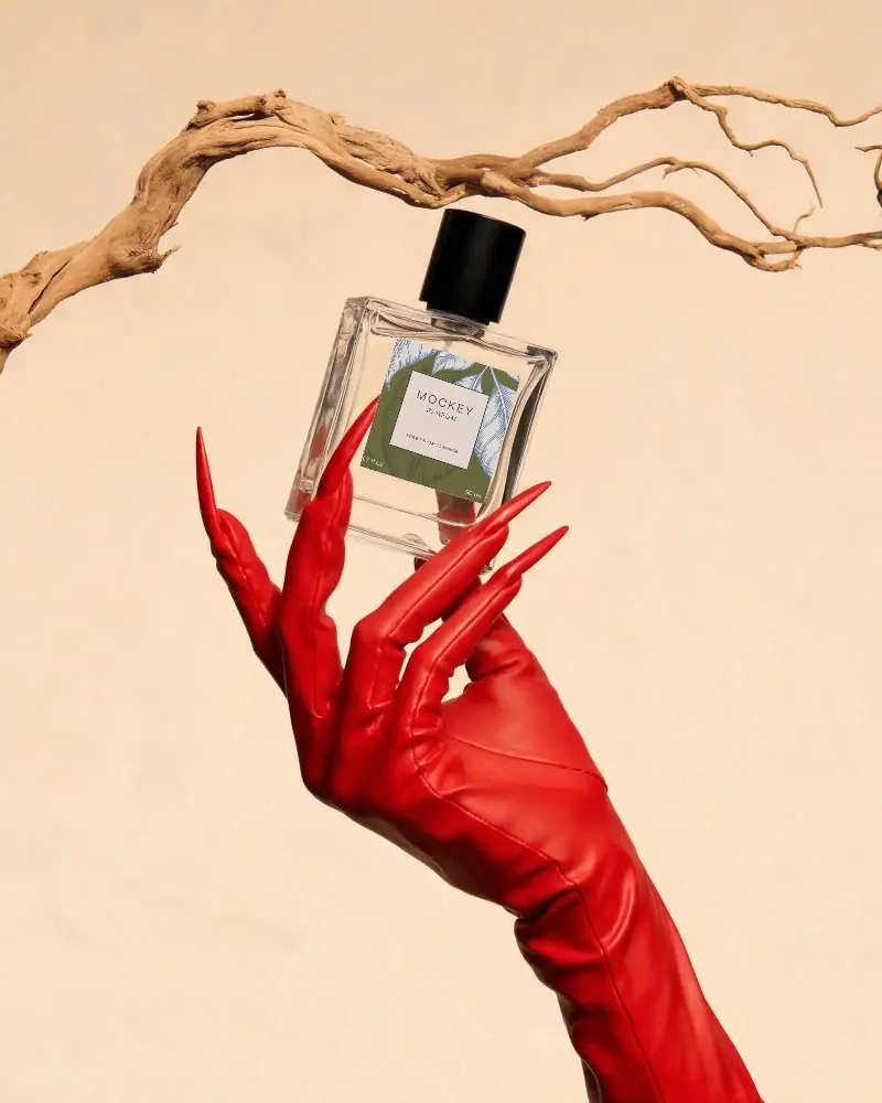 Luxury Perfume Bottle With Blank Label Held By Fashion Gloved Hand Against Minimalist Backdrop