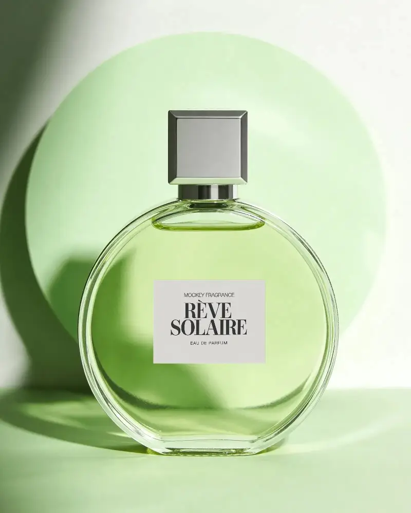 Modern Round Glass Perfume Bottle With Minimalist Label And Metallic Cap Presented In Studio