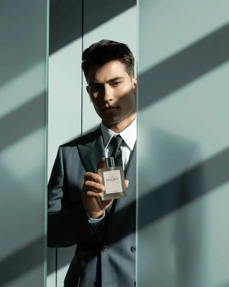 Modern Masculine Perfume Mockup Man In Suit Holding Fragrance In Stylish Light And Shadow
