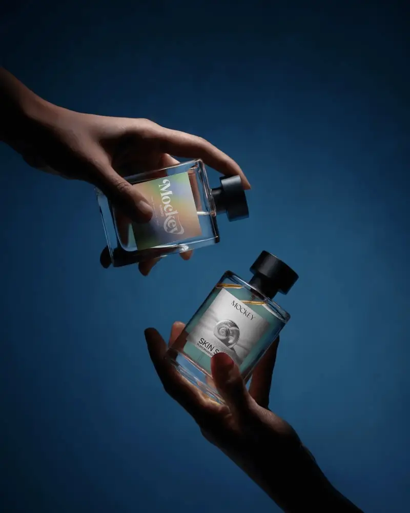 Hand Held Perfume Mockup Dual Glass Bottles Dark Blue Background Dramatic Lighting