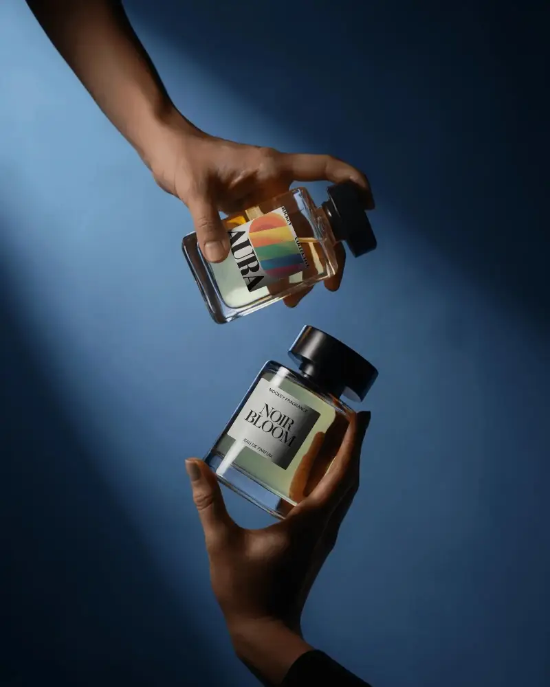 Hand Held Perfume Mockup Dual Glass Bottles Against Deep Blue Background Cinematic Lighting