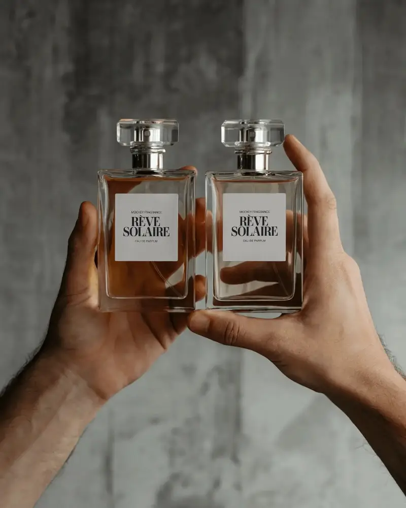 Hand Held Perfume Mockup Dual Glass Bottles Front View Industrial Concrete Background