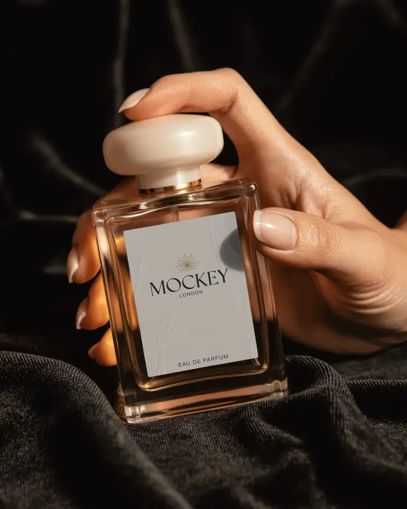 Luxury Perfume Bottle Mockup Hand Holding Glass With Ivory Cap On Black Velvet Luxury Display