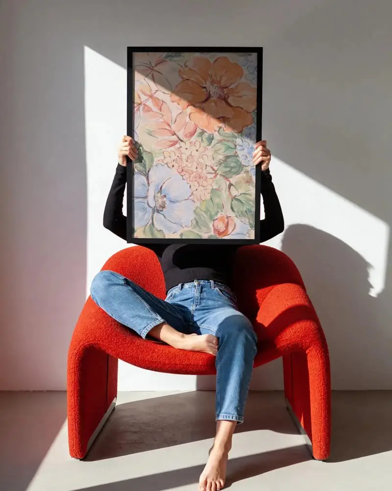 Modern Minimalist Poster Mockup With Person Held Frame And Chair Background